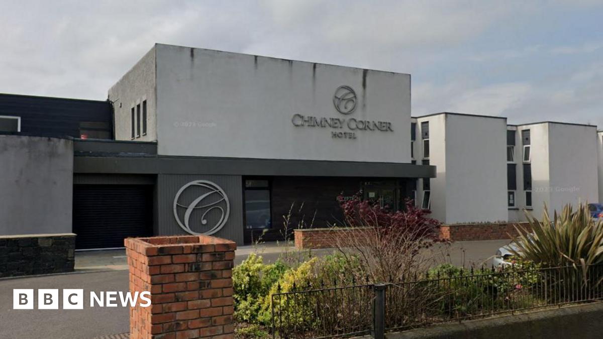 The outside of the Chimney Corner Hotel, which has white and grey walls.