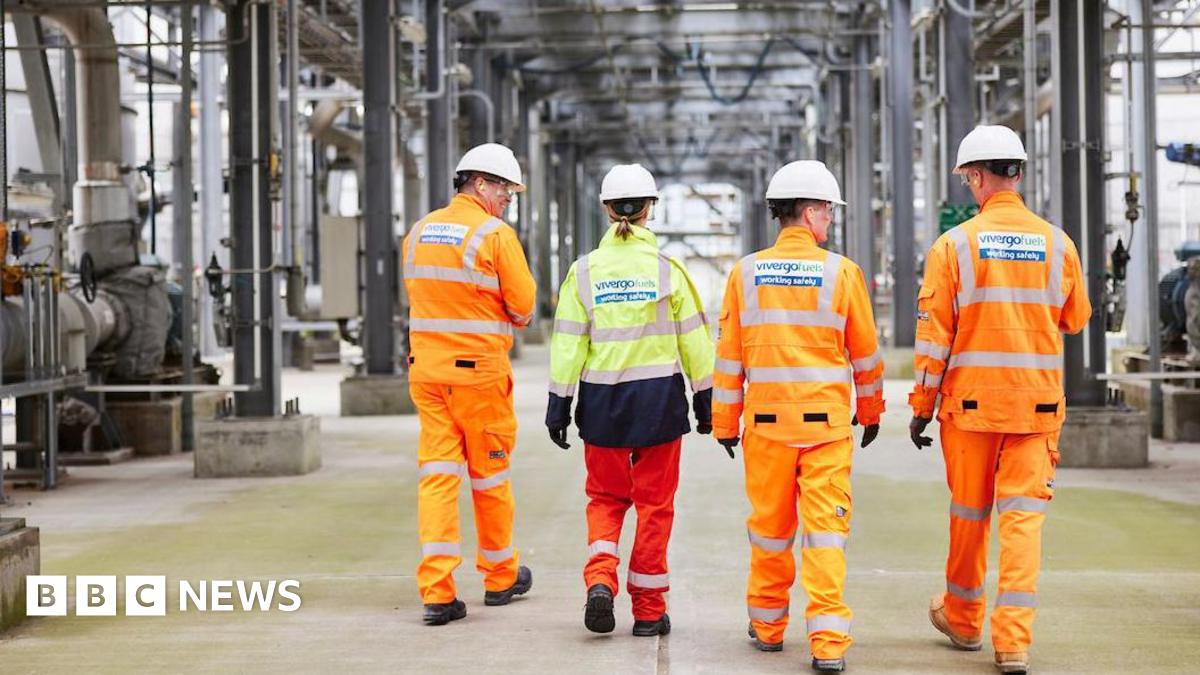 Four Vivergo workers wearing hi-viz outfits walking in front of machinery at the bioethanol plant in Hull