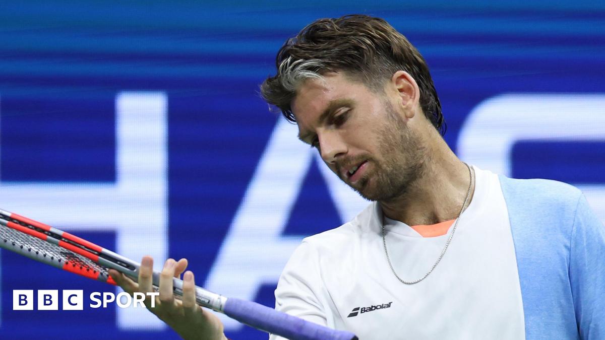 Cameron Norrie looks at his racquet during a 2025 US Open defeat by Novak Djokovic