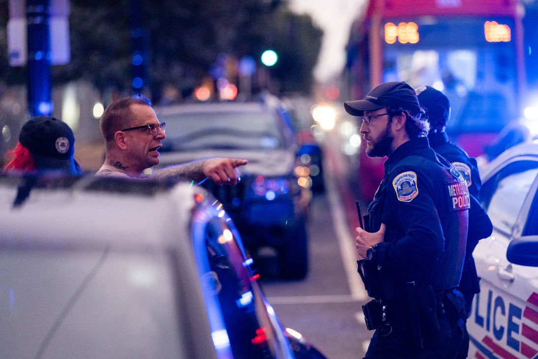 A protester argues with Metropolitan Police Department officers as they detain a man on H Street corridor on Wednesday.