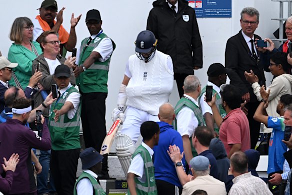 England’s Chris Woakes walks out to bat with his arm in a sling.