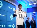 New Vancouver Whitecaps player Thomas Müller poses with his jersey during a news conference in Vancouver, on Thursday, Aug. 14, 2025.