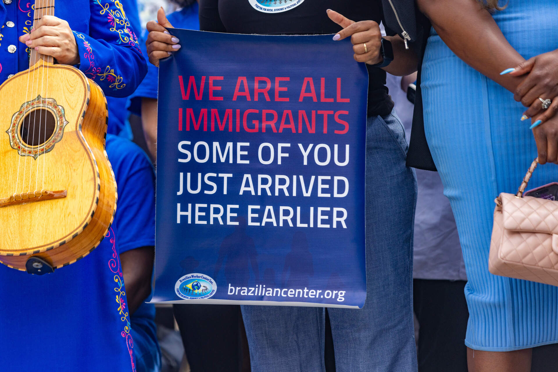 A sign held by a supporter in the crowd during a press conference where Mayor Michelle Wu responds to the recent letter from the federal government demanding the expansion of the city's policies to work with immigration enforcement. (Jesse Costa/WBUR)