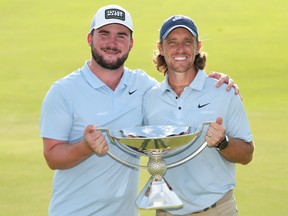 Tommy Fleetwood poses with the Fedex Cup trophy and his stepson, Oscar Craig, after winning the final round of the TOUR Championship.