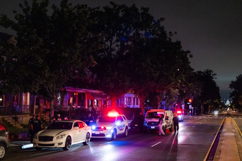 Metropolitan Police Department officers and Homeland Security Investigations special agents prepare to search a vehicle.
