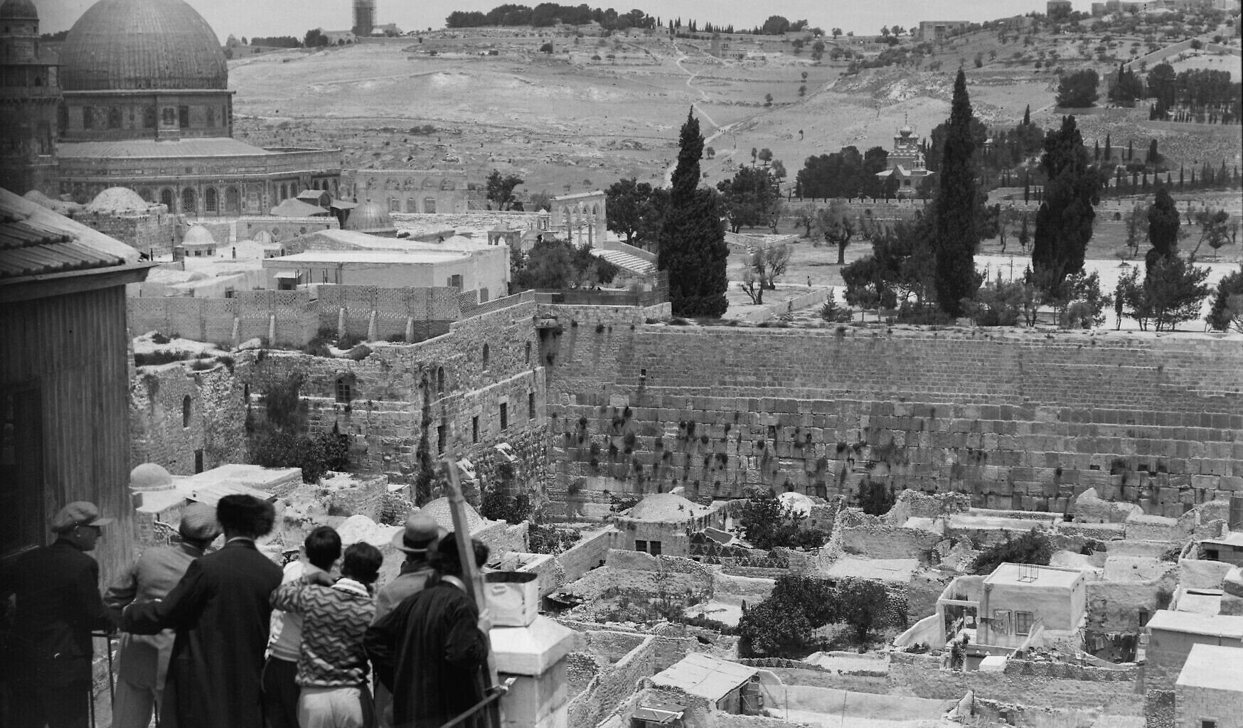 A group of Jews stands on a balcony overlooking the Moroccan Quarter and the Western Wall, with the Dome of the Rock in the distance behind it. Circa 1920–1933. (Library of Congress, Prints & Photographs Division)