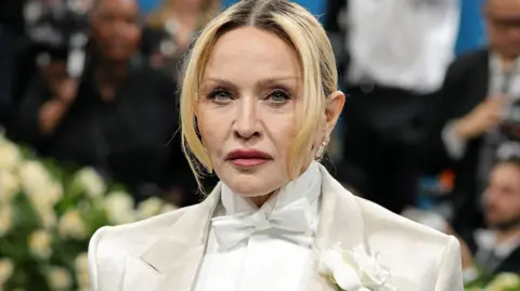 Getty Images Madonna in a white suit looking serious
