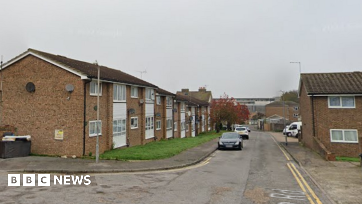 A street view image of a a residential street with brick properties either side of the road