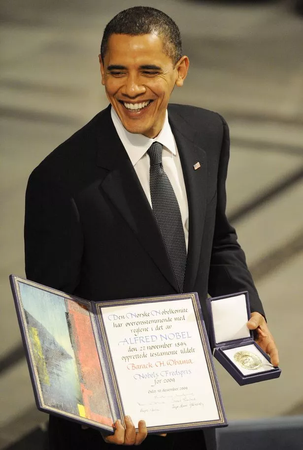 Nobel Peace Prize laureate, US President Barack Obama poses on the podium with his diploma and gold medal during the Nobel ceremony at the City Hall in Oslo on December 10, 2009. 