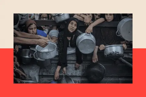 Getty Images Women and children wait in line with bowls and pans