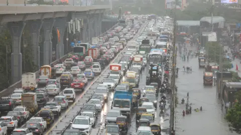 EPA/Shutterstock A view of traffic jam on a flooded street during heavy rains in Mumbai.