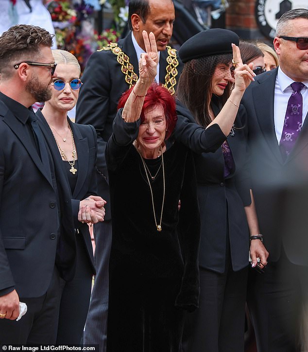 Sharon Osbourne is pictured during Ozzy's funeral last week giving a peace gesture to fans