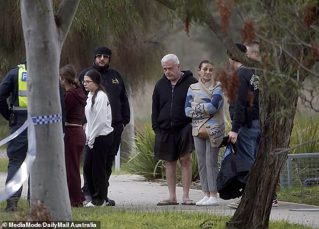 People are seen gathering at the scene of the daylight shooting on Thursday