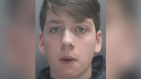 Lancashire Police Custody image of Thomas Dures: a young man with brown hair, wearing a grey hoodie.