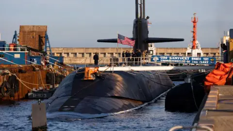 Bloomberg via Getty Images The USS Kentucky ballistic missile submarine on the surface of the water and carrying a US flag, in Busan, South Korea, on 19 July 2023. 