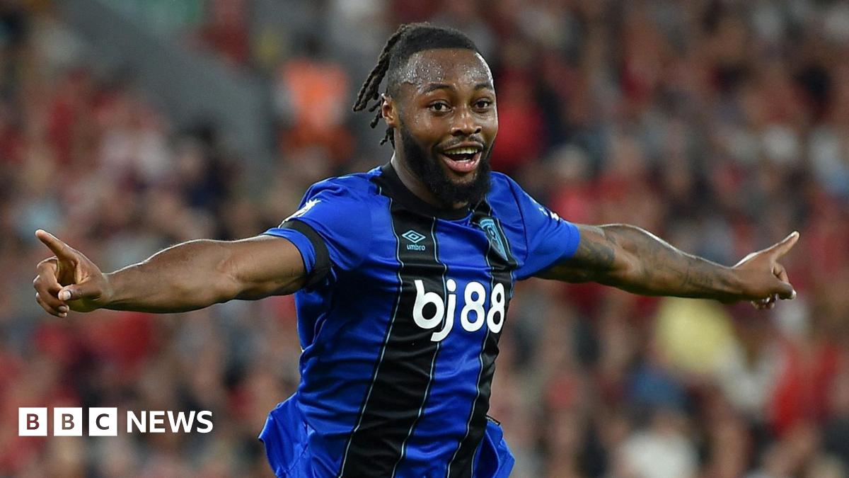 Semenyo celebrating after scoring for Bournemouth. He had short dreadlocked hair and a dark brown beard. He was wearing his dark blue and black Bournemouth away kit.