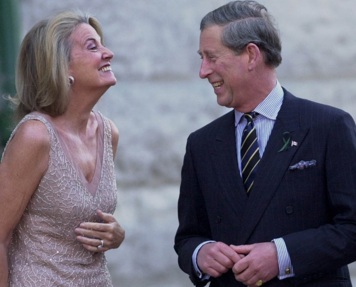 Two people laugh while speaking to each other.