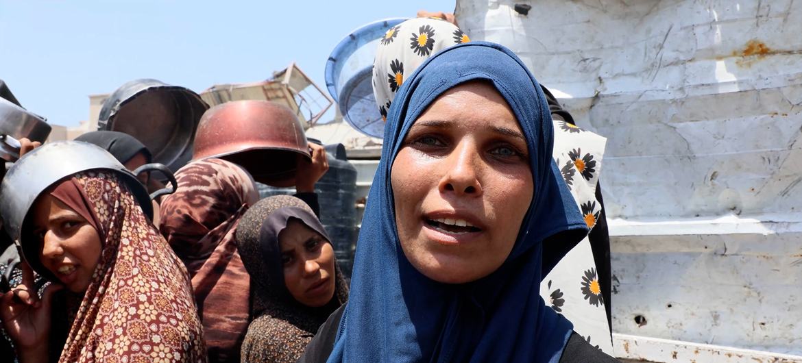 Um Muhammad, who fled from the Shujaiya neighbourhood in eastern Gaza City to its western areas, waits to get food.