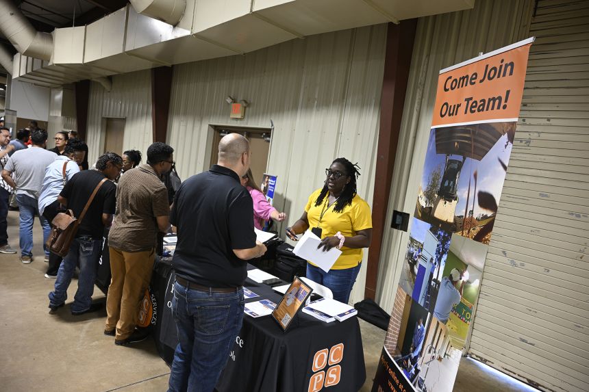 Job seekers talk with representatives from Orange County Public Schools looking to fill openings during a job fair at the Orange County Fairgrounds, on Thursday, July 10 in Orlando, Florida.