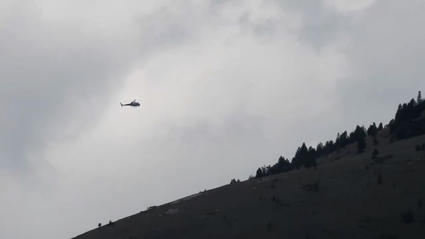 A helicopter circles Garrity Mountain on Saturday in the manhunt for Michael Paul Brown, who is suspected of killing four people at The Owl Bar in Anaconda, Montana.