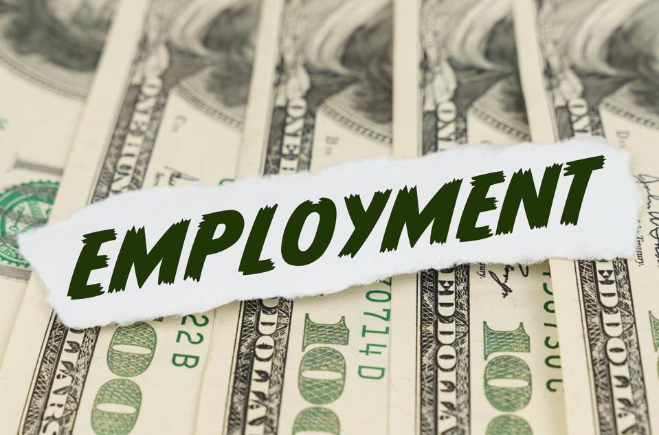 On the background of dollars lies a piece of paper with the text - EMPLOYMENT