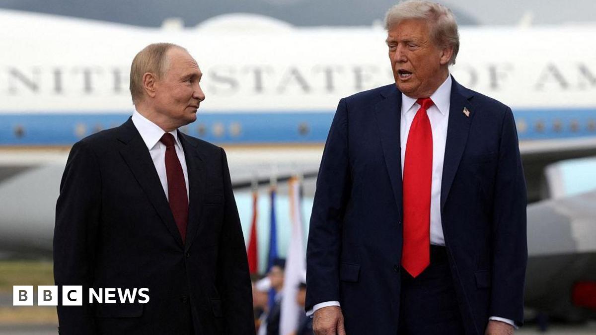 Donald Trump and Vladimir Putin stand side by side and speak as they pose for photos after their arrival for the US-Russia summit