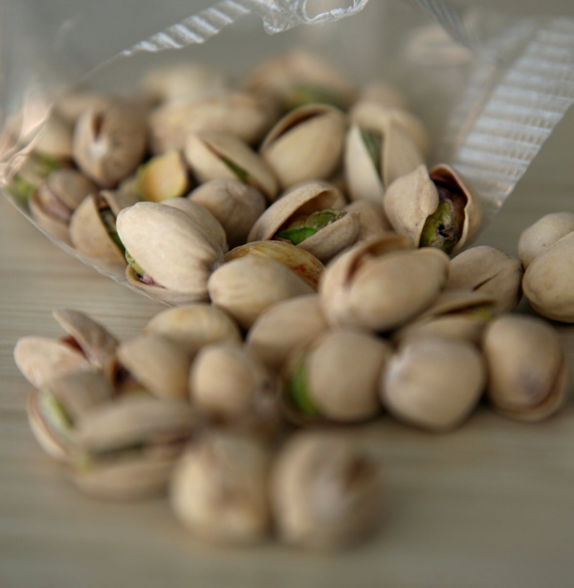 A bag of pistachio nuts with shells.