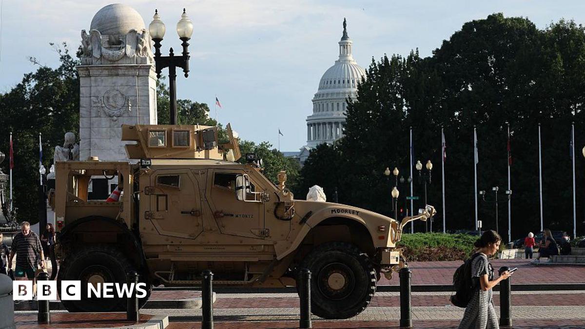 Pedestrians pass an MRAP (Mine Resistant Ambush Protected Vehicles) combat vehicle deployed by the Washington DC National Guard outside Union Station. The US Capitol building is in the distance.