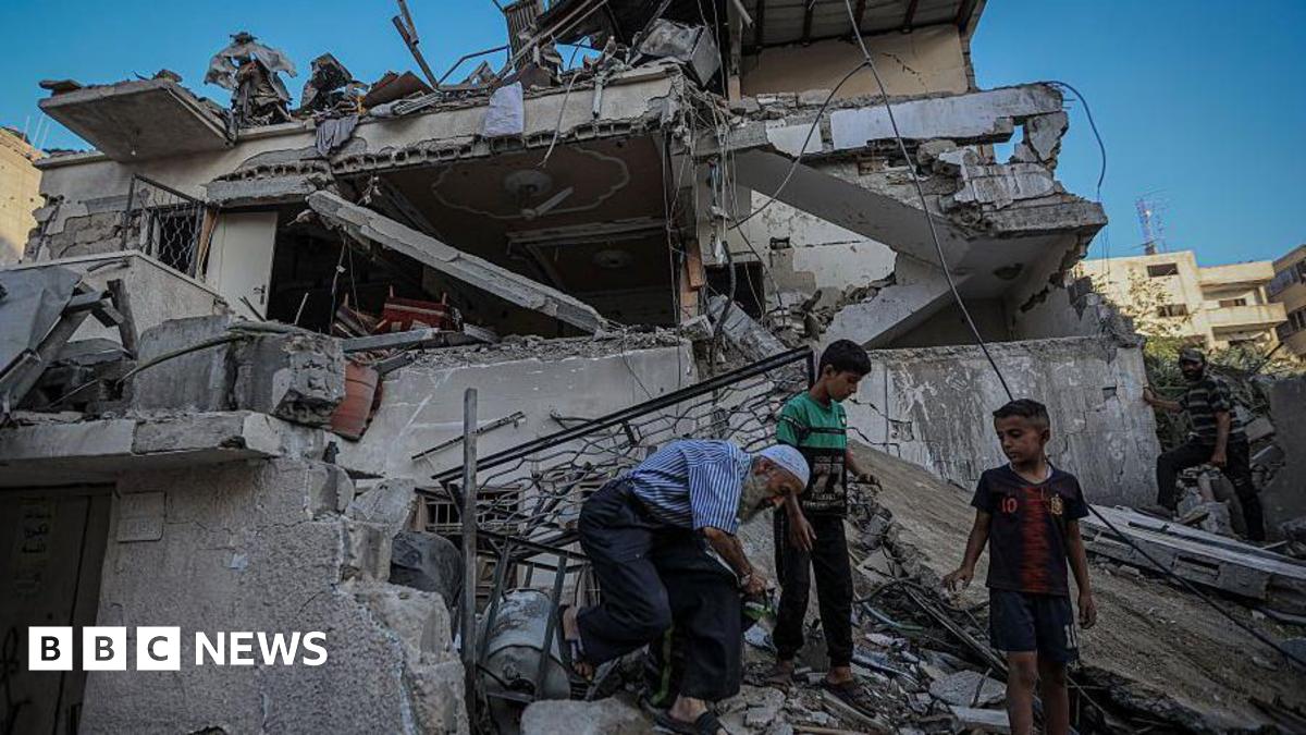 People inspect the damage on a house in Gaza City on August 20, 2025.