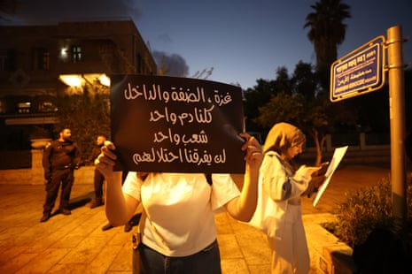 People carrying banners along with photographs of their relatives gather to demand an end to the famine in Gaza and protest against Israeli forces targeting journalists, in Haifa, Israel.