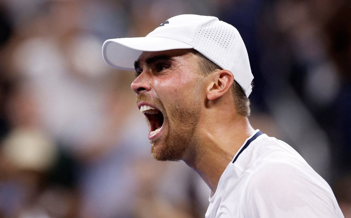 A man in a baseball hat cheers