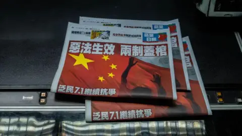 Getty Images "The evil law takes effect and has buried the two systems," read the headlines on copies of Apple Daily in the newspaper's publishing office