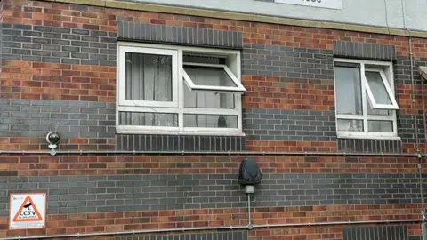 Picture of flats showing two UPVC windows with safety catches released so they are wide open.