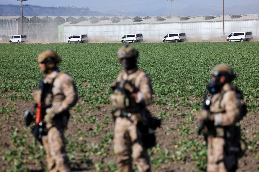 Federal agents stand guard as immigration officers carry out an operation at an agricultural facility in Camarillo, California, on July 10.