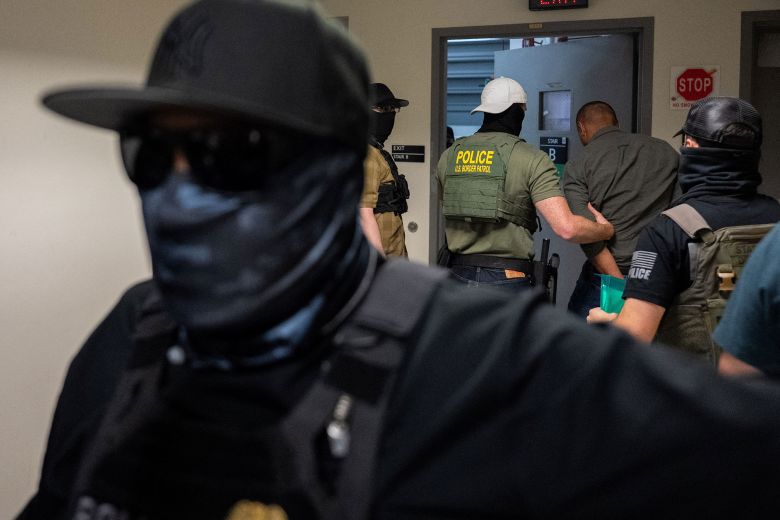 A migrant is detained and escorted by federal immigration officers at immigration court in Manhattan on July 17.