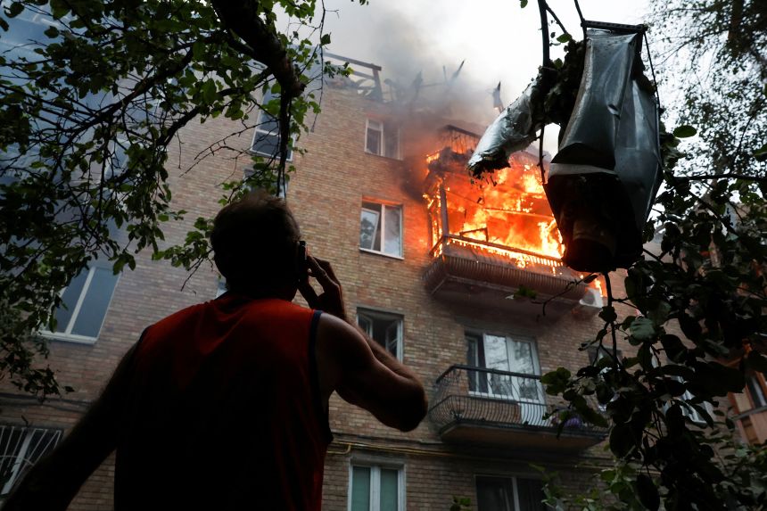 A resident looks at the site of a Kyiv apartment building hit during Russian missile and drone strikes on July 31, amid Russia's full-scale invasion of Ukraine.