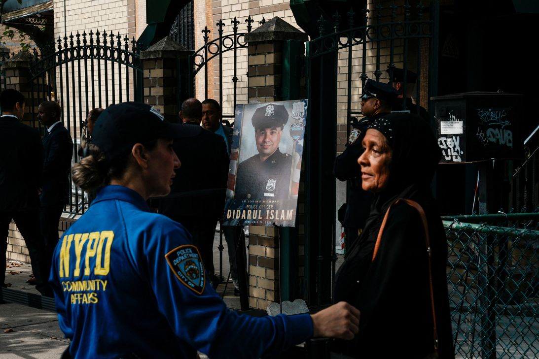 An NYPD employee speaks with a woman outside the funeral service.