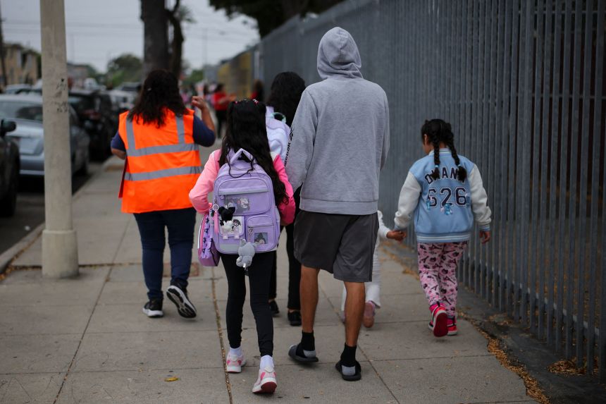 Parents and students arrive for the first day of school at the 93th Street Elementary School in Los Angeles on Thursday.