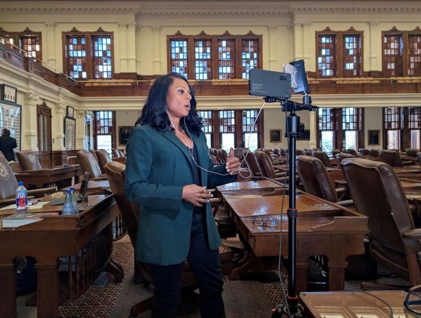 State Rep. Nicole Collier talks on the phone from the floor of the House, where she has chosen to remain until Wednesday, after Democratic lawmakers who had left the state to prevent Republicans from redrawing Texas’s 38 congressional districts returned to the Capitol in Austin, Texas, on August 18, 2025.
