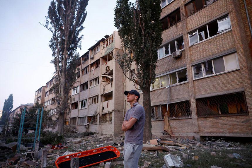 A man stands at the site of a building which was hit by a Russian missile and drone strike, amid Russia's attack on Ukraine, in Kyiv, Ukraine August 28, 2025.
