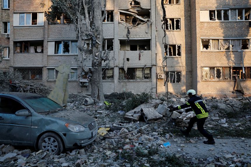 A rescuer works at the site of a building which was hit by a Russian missile and drone strike, in Kyiv on Thursday.