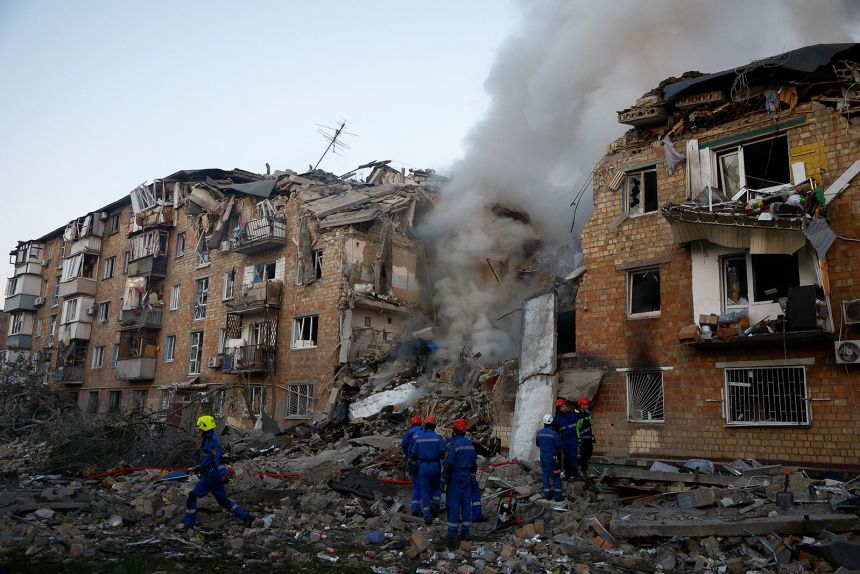 Rescuers work at the site of a building which was hit in Kyiv on Thursday.
