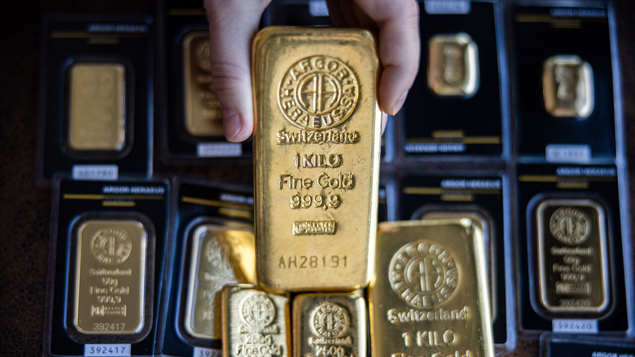 A hand holds an Argor-Heraeus SA one kilogram gold bar