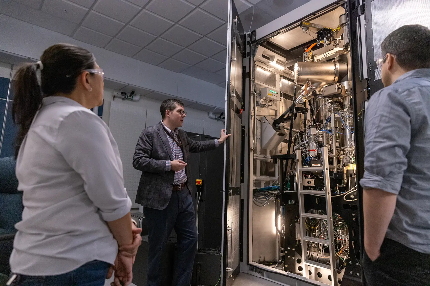 Researchers view an autonomous electron microscope in the basement of the Solar Energy Research Facility at NREL.