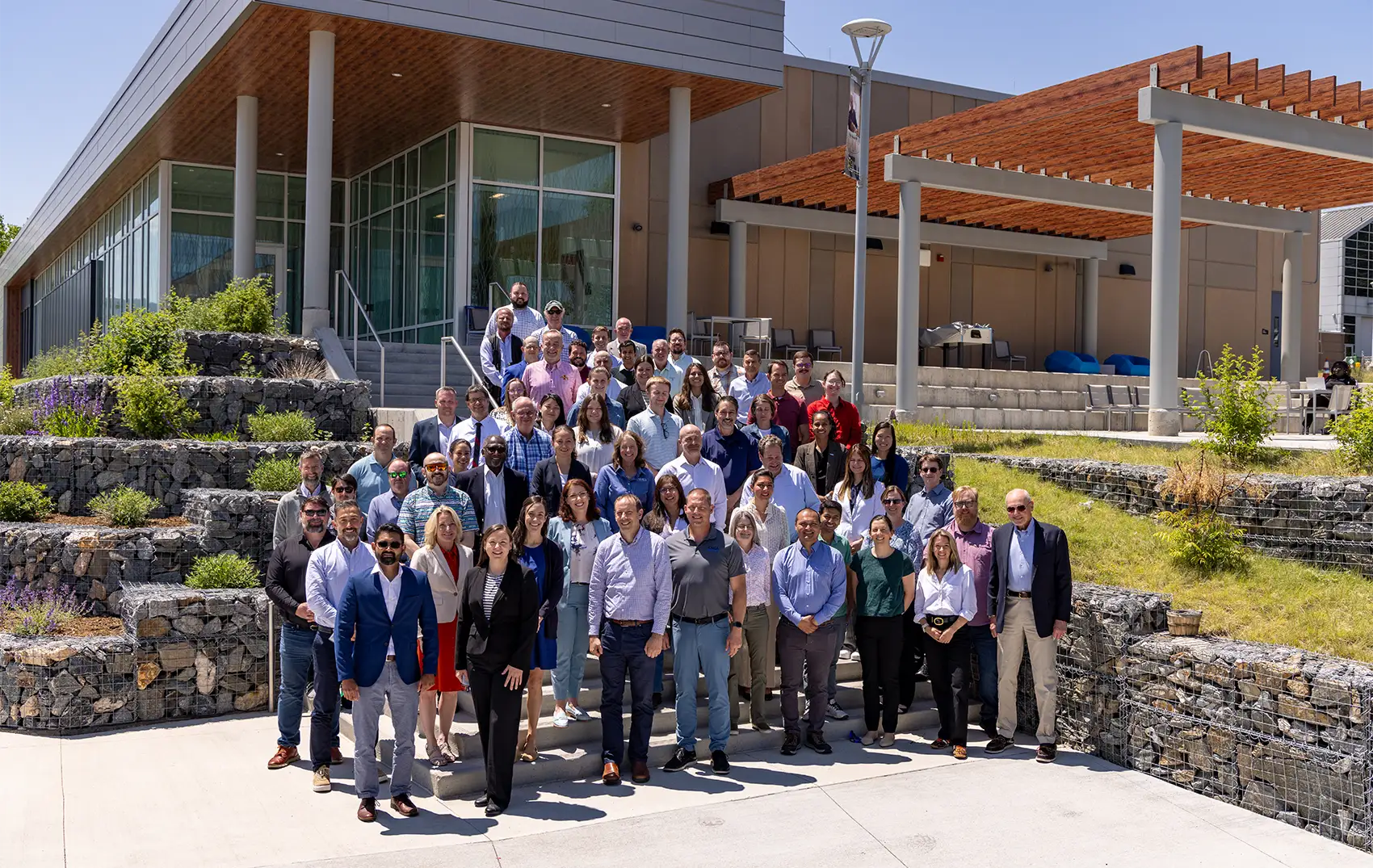 A group of 80 people stand in front of a building.