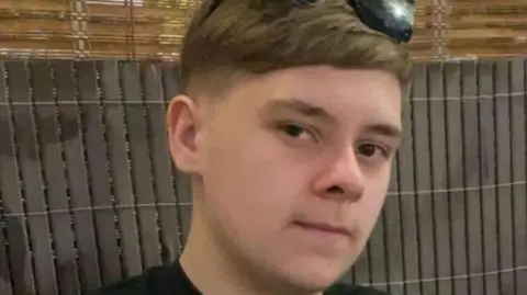 Family handout A teenage boy with dark hair and sunglasses on his head. He is starting into the camera. A fence is behind him.
