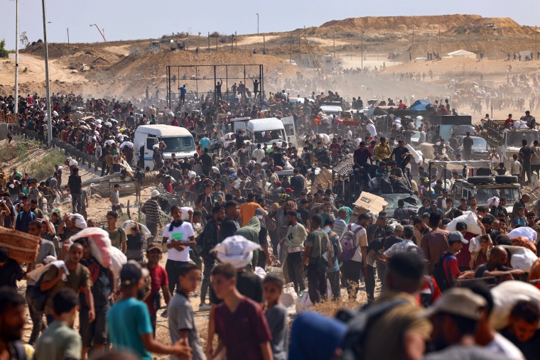 Displaced Palestinians gather to receive aid.