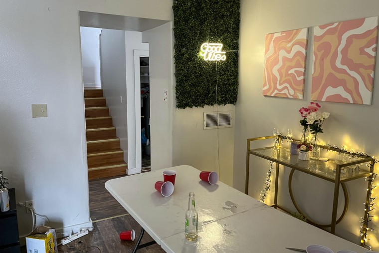 Living room with black couch, party items and backpack on floor.