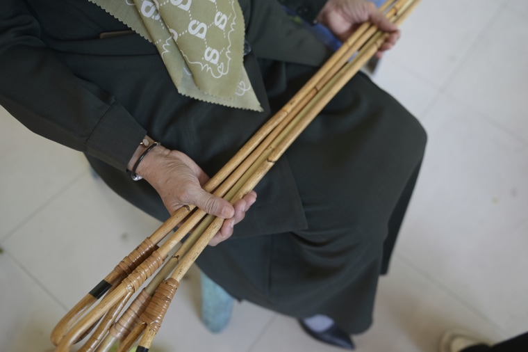 An official holds rattan sticks before a caning in Indonesia