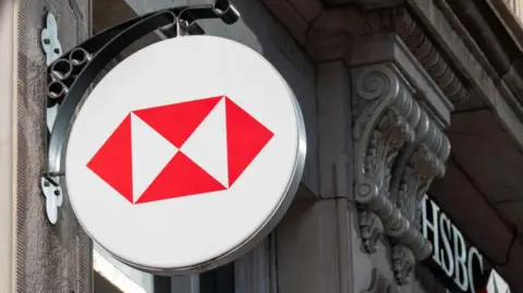 Getty Images The HSBC logo on the side of a building in the UK. It is four red triangles inside a white circle.